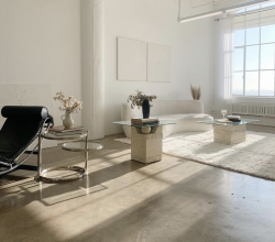 Natural light coming through the windows onto the couch, center pieces, carpet, and chairs inside a photo studio rental in Downtown, Los Angeles, CA